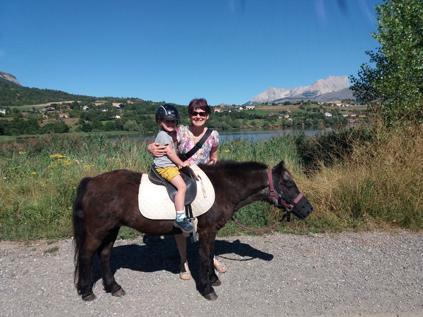 Promenades à poney tenu en main par un parent au bord du lac - © Giansetto Claudine