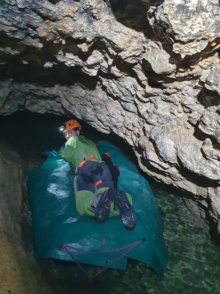 Passage d'une voûte mouillante avec un bateau, dans la cavité du Puits des Bans - © ESC